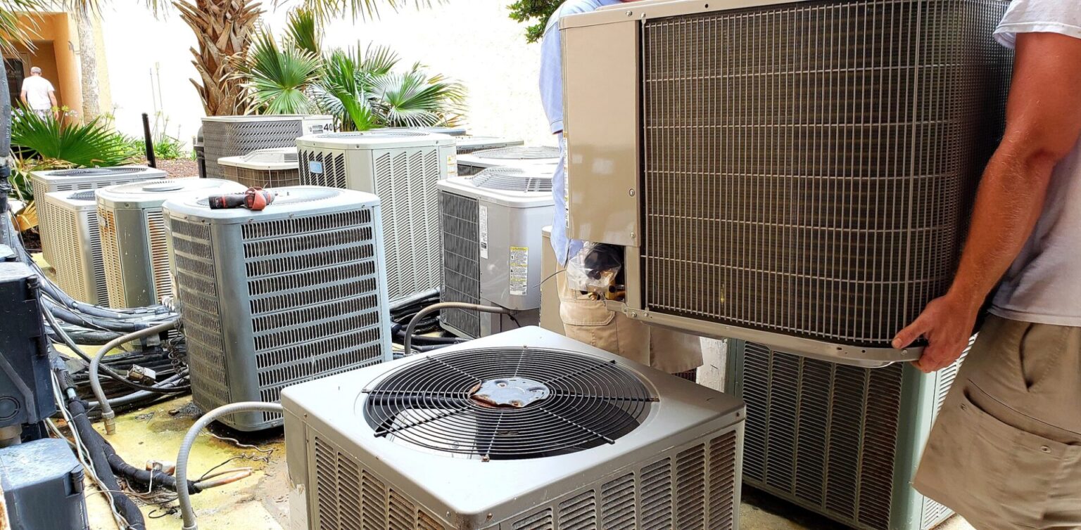 hvac technician removing old rusted broken airconditioners in HVAC at beach condo.